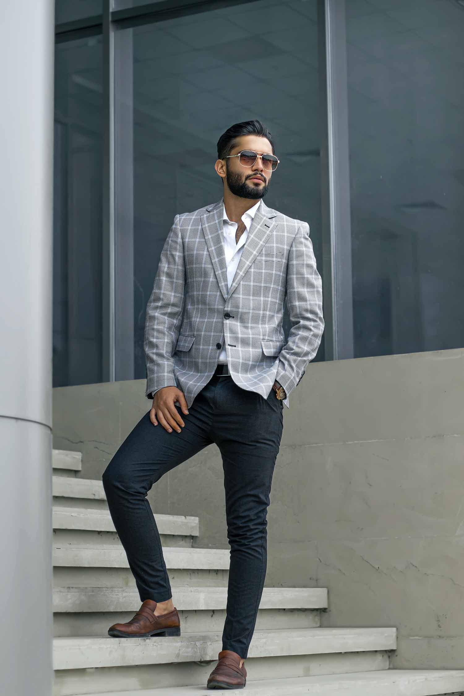 Man posing on stairs wearing a jacket and pants